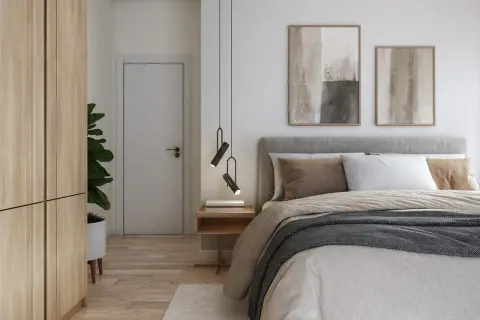 Ett modernt och vackert sovrum med en stor säng, trägarderob, dörr och konst på väggen.