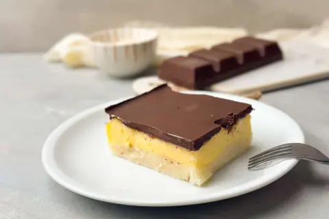 Ein Stück Schokoladenkuchen mit gelber Füllung und dunkler Schokoladenglasur. Perfekt, um mich doof Kuchen zu essen!