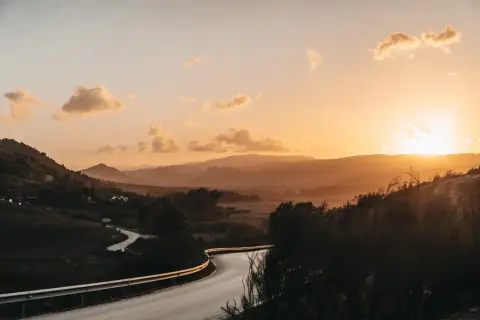 Kurvige Straße in Andalusien bei Sonnenuntergang. Berge und Täler in warmen Farben, ein Highlight der Landschaft.