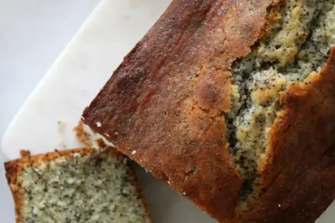 Un délicieux cake citron pavot, doré et moelleux, avec une tranche coupée. Parfait pour le goûter.