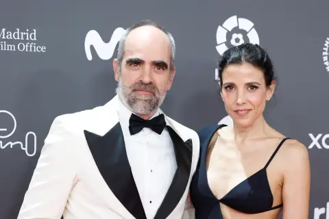 Luis Tosar y su pareja posan en la alfombra roja. Él, con esmoquin blanco y ella, con un elegante vestido negro.