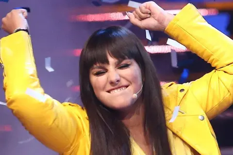 Ewa Farna w żółtej ramonesce, z uniesionymi rękami i konfetti, śpiewa "Bez łez".