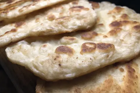 Stos chlebków naan, idealnych do indyjskich dań. Gdzie kupić świeży chlebek naan?