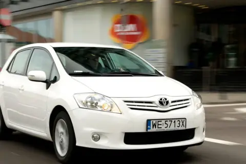 Biała Toyota Auris 1.4 D4D w ruchu miejskim.