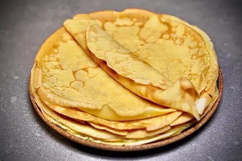 Pile de crêpes dorées et moelleuses, parfaites pour une recette facile.