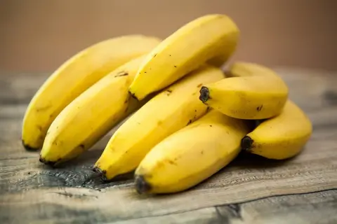 Kupka żółtych bananów na drewnianym blacie. Czy banany są zdrowe? Tak, to pyszna i pożywna przekąska!