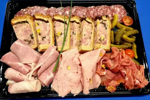 Plateau de charcuterie : terrines, jambon, saucisson, cornichons et tomates cerises. Idéal pour savoir que mettre dans un plateau de charcuterie.