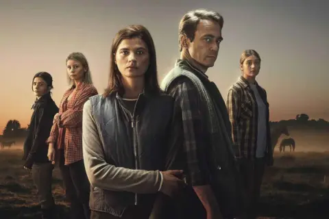 En familj står i en dimmig åker med hästar i bakgrunden. En ny svensk serie som utlovar drama och mystik.