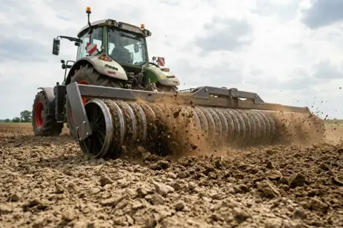 Traktor z wałem uprawowym przygotowuje pole. Zastanawiasz się, co najlepiej uprawiać dla zysku?