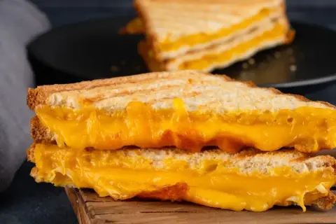 Dos sándwiches de queso a la parrilla, con queso derretido y dorado, el mejor queso para sandwich.