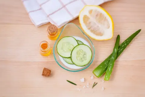 Natürliche Zutaten für ein Beauty-Tag zuhause: Gurkenscheiben, Aloe Vera, Zitrone und Öle.