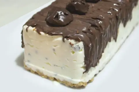 Pyszne lody cassate w kształcie bloku, oblane czekoladą i ozdobione czekoladowymi kuleczkami.