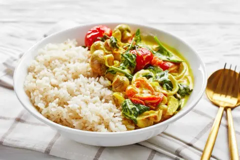 Pyszne dania na ciepło bez mięsa: ryż z aromatycznym curry warzywnym, pomidorkami i szpinakiem.