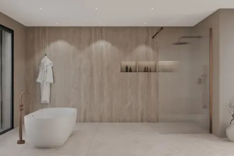 Élégante salle de bain beige et blanc avec baignoire îlot, douche vitrée et peignoir blanc suspendu.