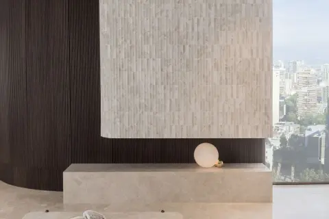 Detalles de cómo revestir una pared con azulejos de mármol y paneles oscuros, creando un diseño moderno.