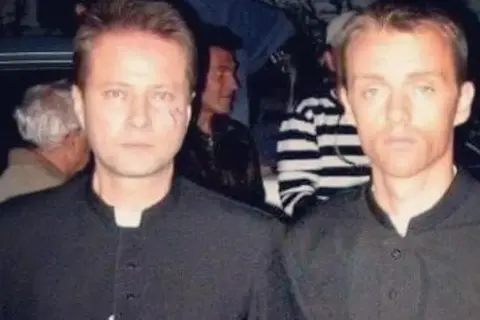 Dwóch mężczyzn w czarnych koszulach, jeden z blizną na policzku, wygląda jakby to oni byli tym, kto dubluje polskie gwiazdy w niebezpiecznych scenach kaskaderskich.