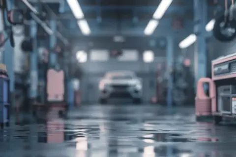 Wnętrze warsztatu samochodowego, gdzie czeka auto. Widać narzędzia i sprzęt, gotowe do pracy w mobilnym warsztacie samochodowym PKD.