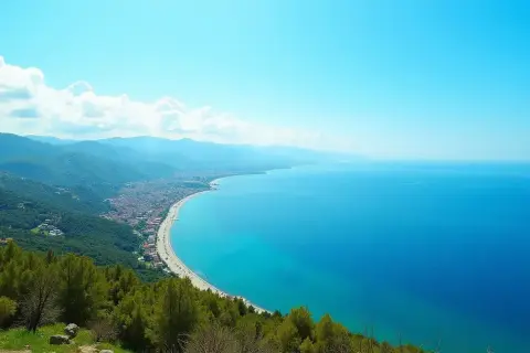 Widok na wybrzeże Turcji, gdzie turkusowe morze obmywa piaszczystą plażę i zielone wzgórza.