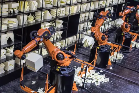 Roboterarme im Museum der Industriekultur formen weiße Objekte.