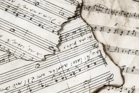 Spalone nuty, fragmenty zapisu muzycznego. "Adagio co to znaczy?" - wolno, powoli, jak w tej starej melodii.