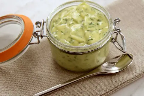 En burk med krämig bearnaisesås, perfekt för ditt nästa bearnaisesås recept. En sked ligger bredvid.