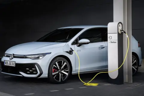Jasnoniebieski Volkswagen Golf GTE podłączony do stacji ładowania e-Station.