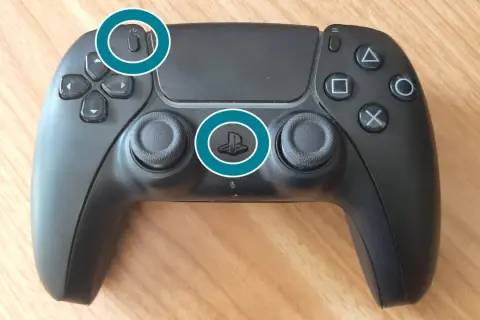 Schwarzer PS5 Controller mit hervorgehobenen Tasten für Bluetooth-Kopplung und Power.
