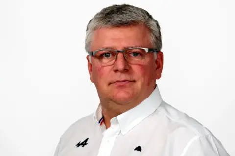 Otmar Szafnauer, con gafas y camisa blanca con logo de Alpine, mira fijamente.