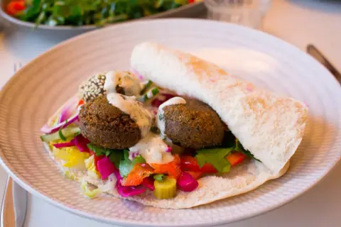 Falafel i pitabröd med färgglada grönsaker och en krämig sås. Ett perfekt falafel recept för en snabb och god lunch.
