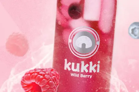 Kukki Wild Berry Drink mit Himbeeren und Blaubeeren auf pinkem Hintergrund.