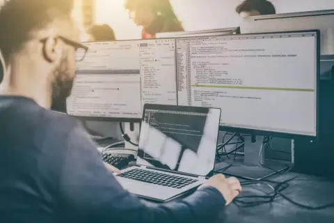 Programista analizuje kod, przygotowując się do pytań rekrutacyjnych tester.