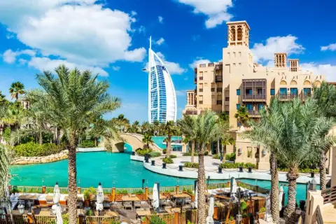 En vacker vy över Dubai med palmer, turkost vatten och Burj Al Arab. Perfekt för att planera dina aktiviteter i Dubai.