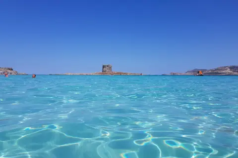 Acque cristalline e un'antica torre in mezzo al mare: uno dei tanti posti di mare belli in Italia.