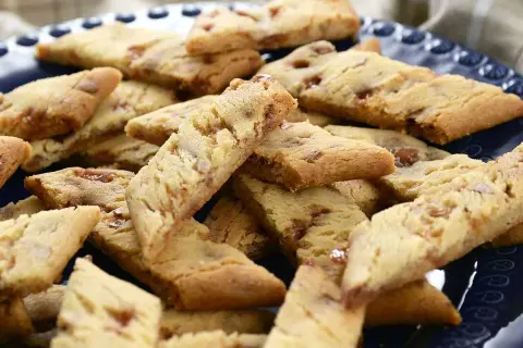 En hög med gyllene kolasnittar med daim, perfekta för fikat.
