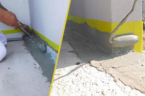Arbeiter versiegeln Fugen der Terrasse mit einer grauen Masse. Gelbes Klebeband schützt die Wand.