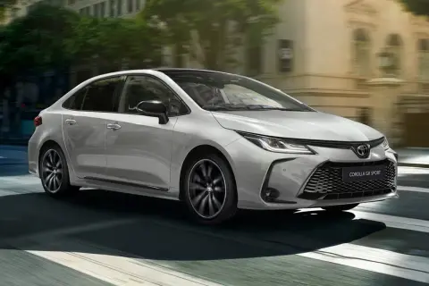 Srebrna Toyota Corolla Hybrid GR Sport 2022 w ruchu miejskim. Sprawdź atrakcyjną toyota corolla hybrid 2022 cena.