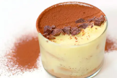 Un bicchiere di tiramisù classico, con crema soffice, cacao e scaglie di cioccolato. Perfetto per chi cerca una ricetta facile e golosa.