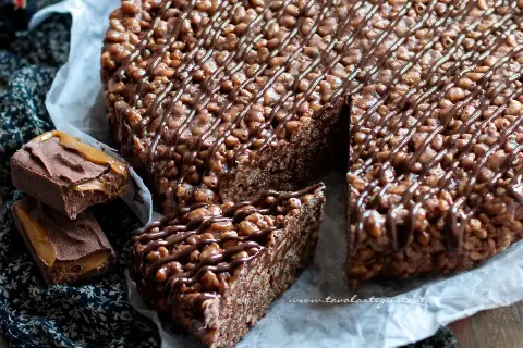 Una golosa torta Mars, con riso soffiato e cioccolato, decorata con caramello e cacao.
