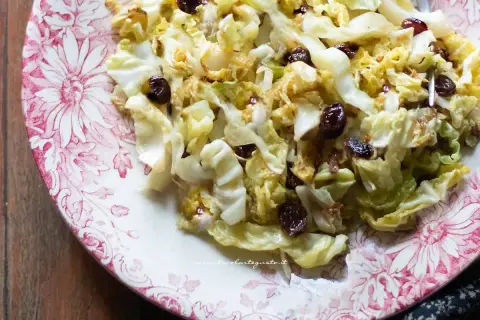 Verza in padella con uvetta, un contorno saporito e colorato servito su un piatto decorato.