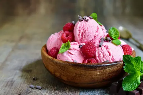 Himbeereis selber machen ohne Eismaschine: Cremiges Eis mit frischen Himbeeren und Minze in Holzschale.
