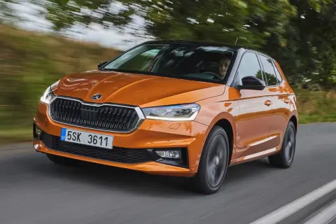 En orange Skoda Fabia kör på en väg. Inga problem med denna bil, bara en härlig tur.
