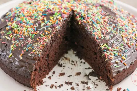 Schokoladenkuchen ohne Ei, üppig mit bunter Streusel-Deko und Schokoladenglasur. Ein Genuss für alle, die es süß mögen!