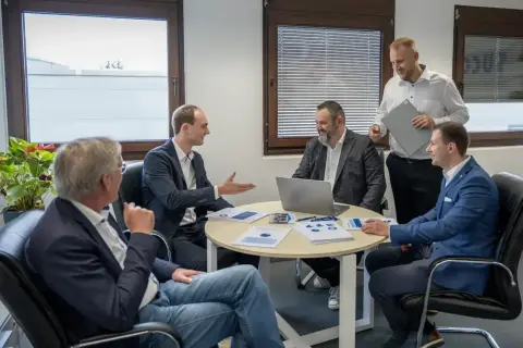 Geschäftsmänner diskutieren über Kennzahlen, wie z.B. die days payable outstanding deutsch, bei einem Meeting.