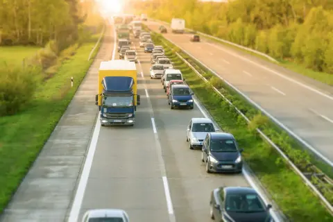 Korek na autostradzie, gdzie samochody i ciężarówka tworzą długi rząd. Kierowcy stosują jazda na suwak, by usprawnić ruch.
