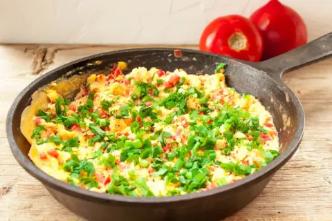 Pyszny omlet na słono z pomidorami i szczypiorkiem na patelni. Idealny przepis na szybkie śniadanie.