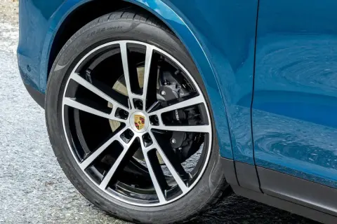 Rueda de Porsche azul con llanta deportiva. Los frenos de alto rendimiento son clave para la distancia de detención y frenado.