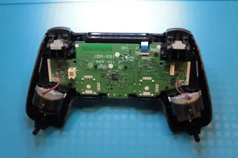Wnętrze pada PS4 z widoczną płytką drukowaną i elementami. Dowiedz się, jak zresetować pada PS4, gdy napotkasz problemy.