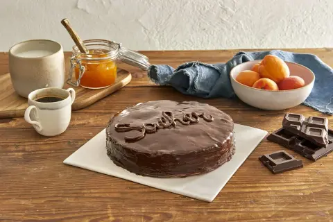 Una deliziosa torta Sacher lucida, con caffè, latte, marmellata di albicocche e cioccolato fondente.