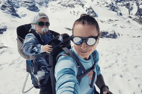 Justyna Kowalczyk z synkiem w nosidle w górach. To jej jedyne dziecko.