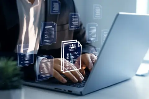Biznesmen pracuje przy laptopie, przeglądając dokumenty. Wirtualne ikony dokumentów unoszą się wokół, symbolizując zarządzanie danymi. Kto to mocodawca? To ten, kto zleca zadanie.